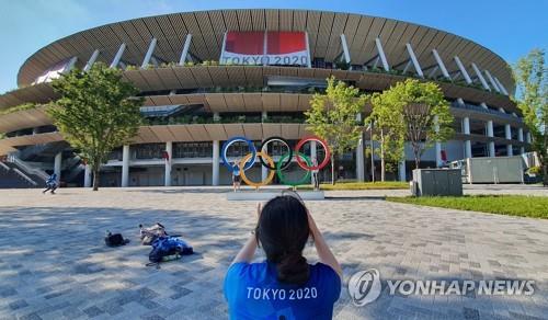 일요일인 1일 오후 도쿄올림픽스타디움 앞의 오륜 조형물 주변에서 자원봉사자들이 기념촬영을 하고 있다. [도쿄=연합뉴스]