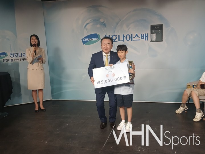 정휘철 청호나이스 부회장이 무릎을 살짝 굽히고 최해권 군과 기념사진을 찍고 있다.(사진 MHN스포츠 엄민용 선임기자)