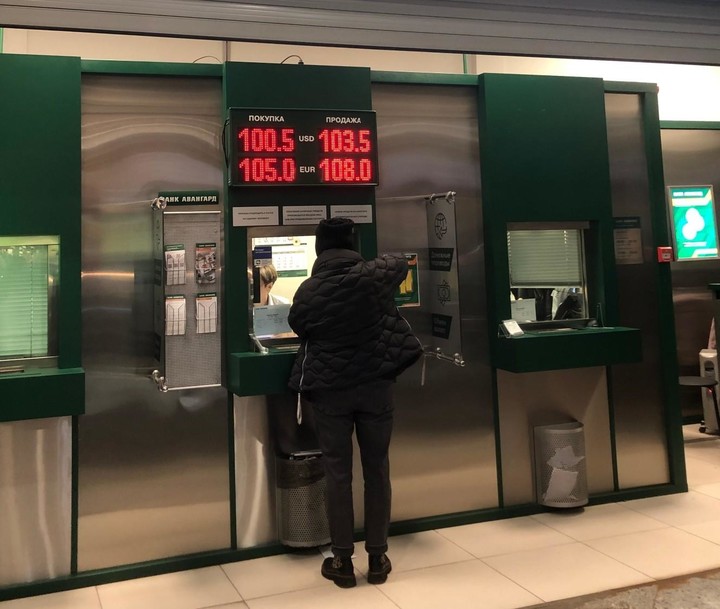 모스크바=연합뉴스 22일(현지 시각) 러시아 모스크바의 한 환전소에서 환전하는 러시아 시민. 전광판에 달러를 100.5루블에 사고 103.5루블에 판다고 공지돼 있다.