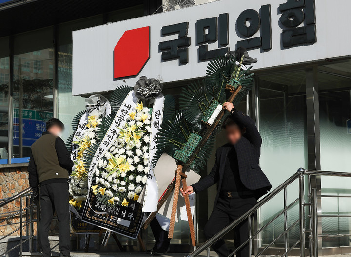 10일 대구 수성구 국민의힘 대구시당 앞에서 시당 관계자들이 시민들이 보낸 국민의힘 규탄 근조화환을 치우고 있다.