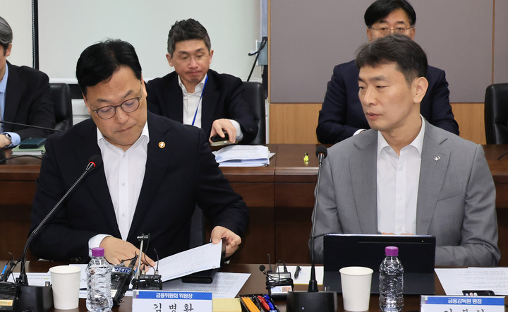 김병환 금융위원회 위원장이 7일 서울 종로구 정부서울청사에서 열린 금융 상황 점검 회의에서 이복현 금융감독원장과 대화하고 있다. 2025.4.7