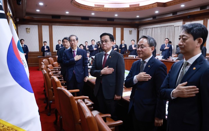 한덕수 대통령 권한대행 국무총리와 국무위원들이 8일 정부서울청사에서 열린 국무회의에서 국기에 경례하고 있다. 이날 국무회의는 헌법재판소의 윤석열 대통령 파면 결정 뒤 열린 첫 국무회의다. 2025.4.8