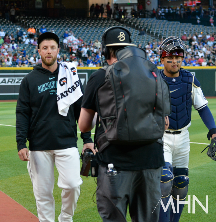 (메릴 켈리(왼쪽)가 불펜에서 선발 등판 준비를 마친 뒤 더그아웃으로 포수와 함께 이동하고 있다)