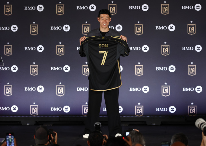 (손흥민이 7일(한국시간) LA FC 입단기자회견장에서 자신의 유니폼을 들고 포즈를 취하고 있다)