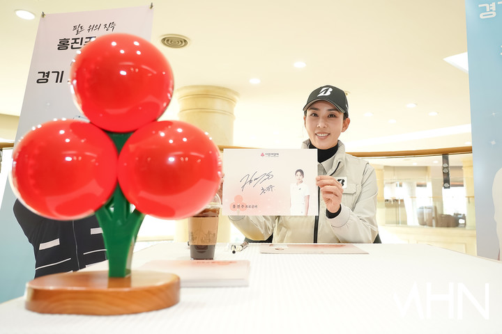사인회에 참여 한 홍진주가 사인을 들어보이고 있다